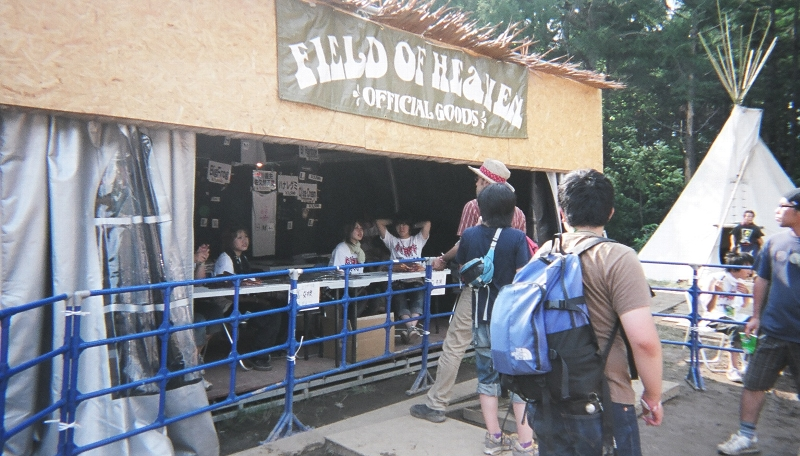 フィールド・オブ・ヘブンとオレンジ・コートの出演者のTシャツ等はフィールド・オブ・ヘブンで販売しています。店の外観もフィールド・オブ・ヘブンの雰囲気に合わせています。すべてのアーティストがTシャツ等を出しているわけではなく、特にフィールド・オブ・ヘブンとオレンジ・コートの出演者はアーティスト・グッズがもともとないことがあります。グリーン・ステージとホワイト・ステージのアーティストはグリーン・ステージの北側で販売されています。