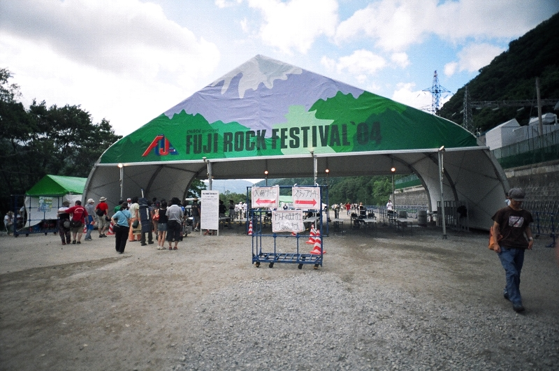 入場ゲート。左が一般用、右がスタッフ用になっていますが、入場者が多いときはほとんどが一般用となります。午前9時の開場前は200メートルくらいの行列になります（あくまでも04年の場合です）。チケットのままでは入場できないので場外ショップエリアに戻ってリストバンドの交付を受けなければなりません。