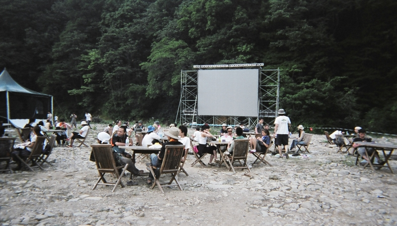 いす、テーブルもあります。左に見える緑のテントは、森をバックにライティング・アートを見せる設備があります。夜ここを通るととても幻想的なアートが見られます。