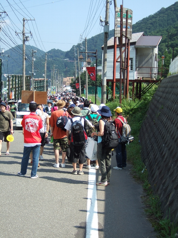 開催初日、開場時間の午前9時には、行列が苗場プリンスホテルの入り口、三国の交差点付近まで続きます。赤いジャケットを着ているのはスタッフで、行列の最後尾を示すプラカードを持っています。ここから実際に入場するまで20分から30分かかります。