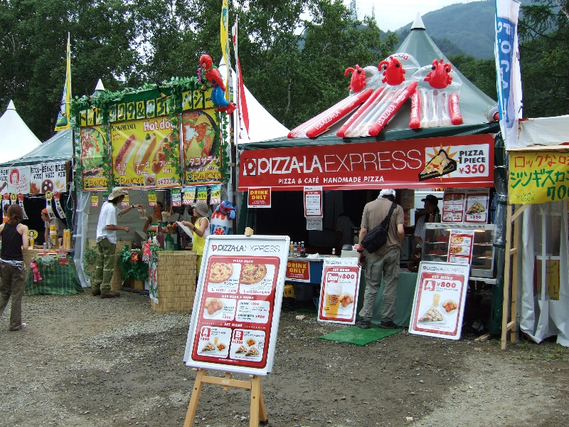 ピザーラ。全国チェーン店が出店するのは珍しい。50円単位の値段設定はフジ・ロック会場内では珍しい。ピザーラの隣はホットドッグ屋。シーザーサラダは容器一杯のサラダが食べられます。