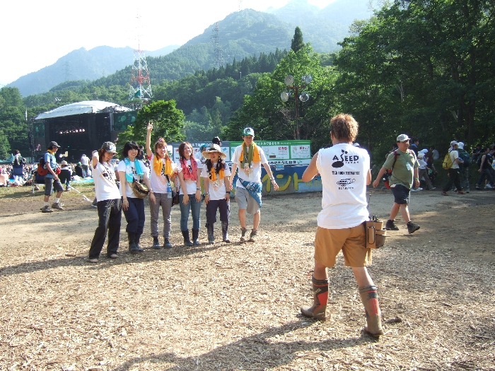 3日目の午後、グリーン・ステージをバックに記念撮影するボランティア団体の人。