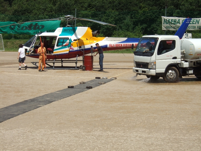 右の車は散水車。運動場を発着場としているため、離着陸のときは砂ぼこりが舞います。天候が晴れている場合、すぐに運動場が乾くので、それを防ぐため水をまきます。