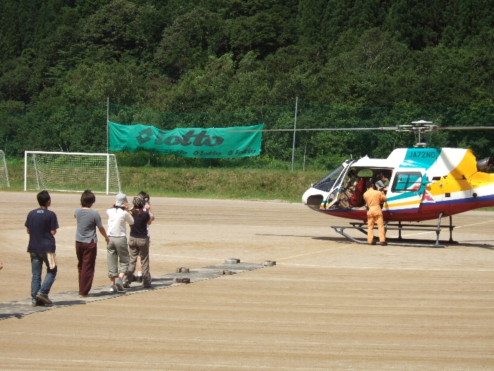 次に乗る人は一列に並んでヘリコプターに向かいます。