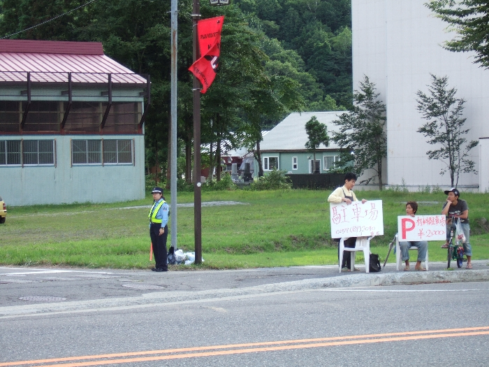 浅貝駐車場の入り口で有料駐車場を宣伝する人。