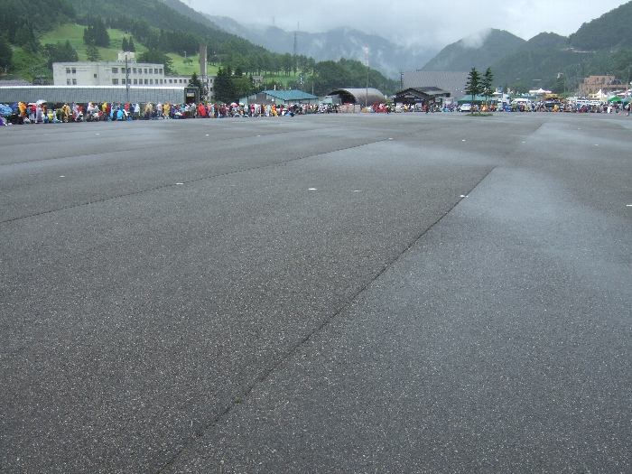 この広い場所も駐車場に利用されます。アスファルトの白い点は駐車の際の目印です。この場所に車を誘導するころには、左に並んでいる人の列も解消しているので、接触事故などは起こらないようになっています。