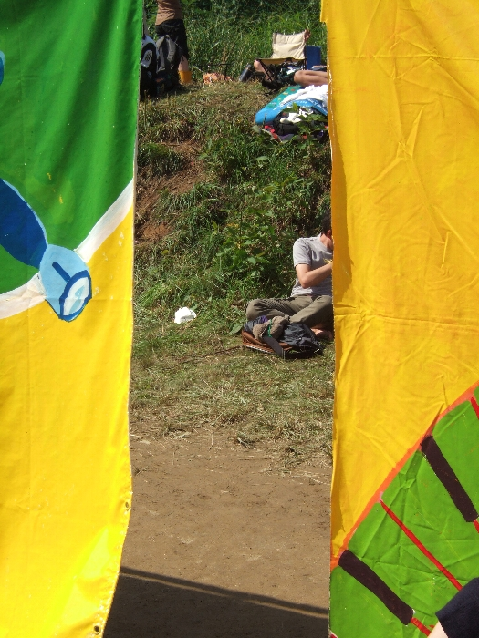 オレンジ・コートと土手を仕切る壁にはところどころにすき間があり、そこから出入りしている人もいます。 