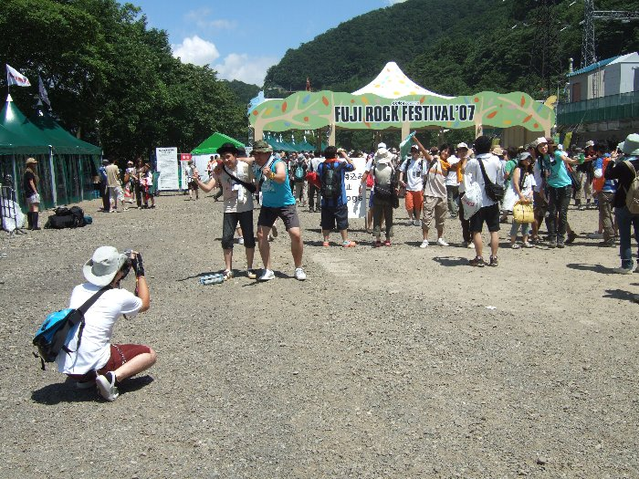 入場ゲートを背景に記念撮影する人たち。