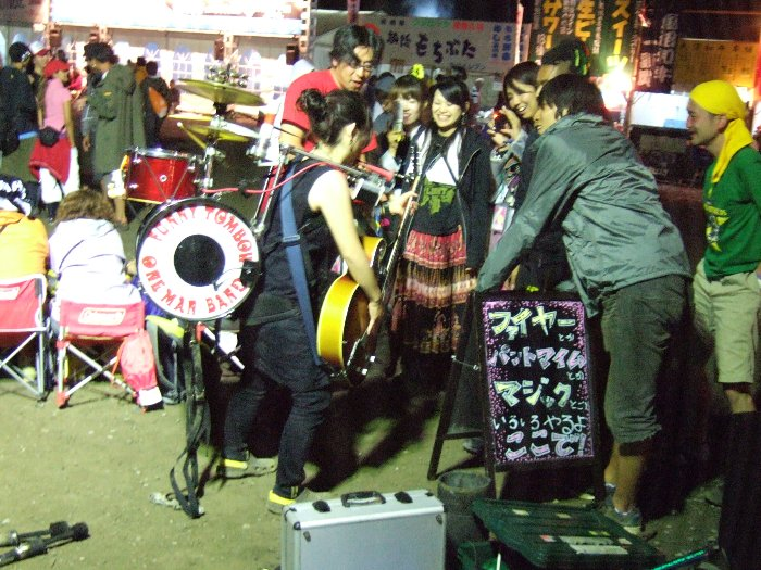 3日目午前3時すぎ。ワンマンバンドのセットを試しに装着してもらった小柄な女性。