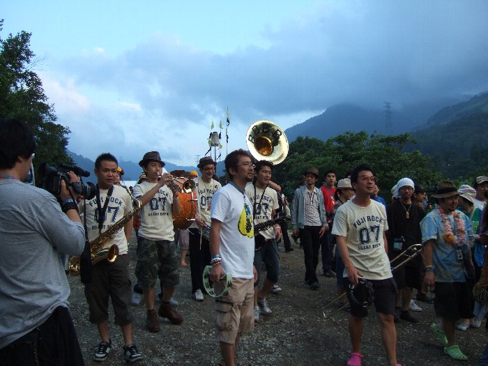 入場ゲートを歩きながら演奏するブラック・ボトム・ブラス・バンド。入場者と一緒に行進中。 