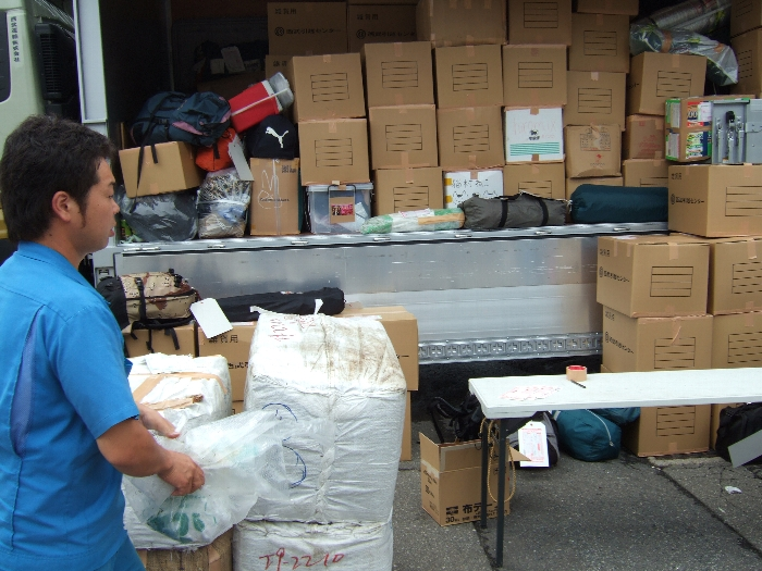 宅配便の荷物を積み込む人。 