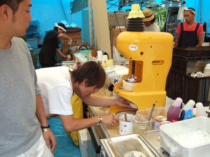 アイスの塊をかき氷のように削っています。 