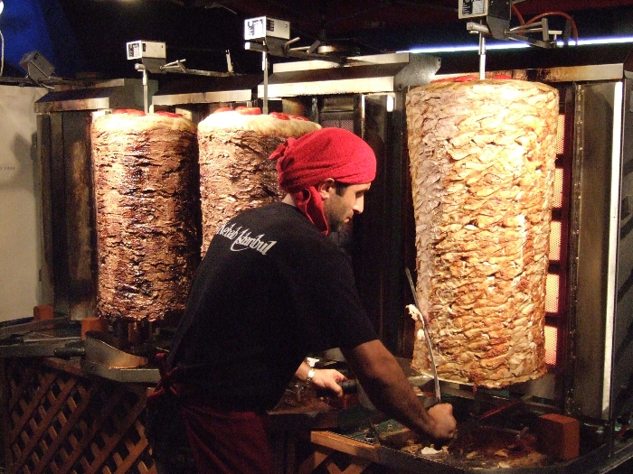 刀のようなナイフで肉を切り落としているところ。 