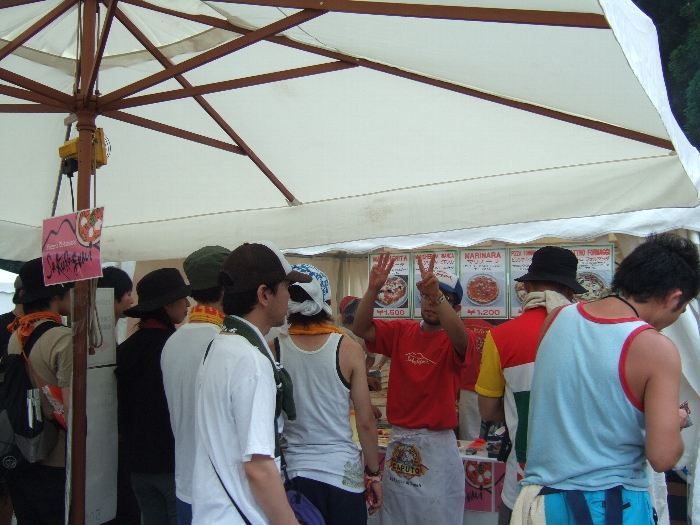 注文の番号を指で確認する店の人。 