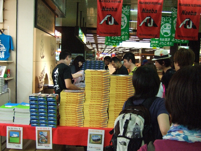 大量に積まれたフジロック・クッキーとせんべいとパンフレット。