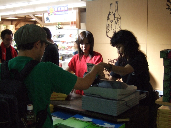 臨時のレジで客をさばく女性。