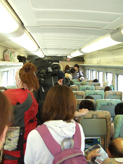 上越新幹線越後湯沢駅到着時の新幹線車内。大きな荷物を持った若い人がたくさん降りていきます。