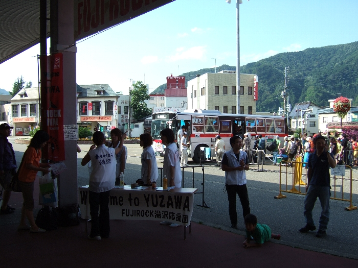 駅の出口で案内をする（たぶん）ボランティアの人たち。逆光です。
