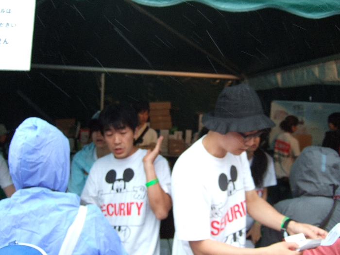 リストバンド交換所でリストバンドを手渡す人たち。