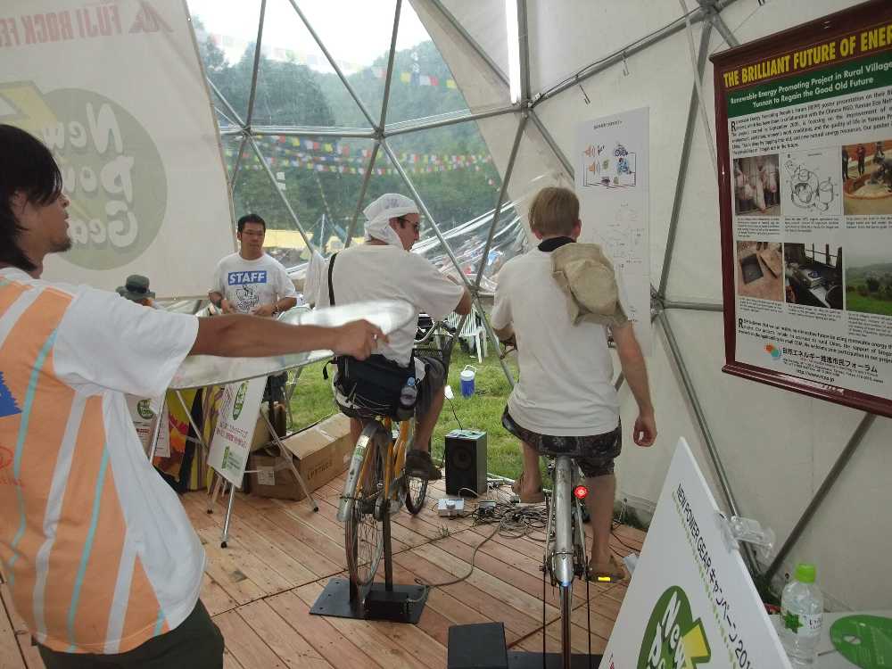 自転車発電。手前の人は扇ぐ人