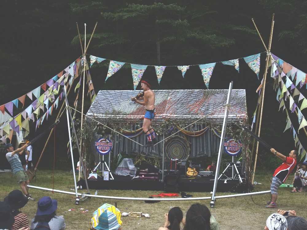 バイオリンを弾きながら綱渡りをする人。