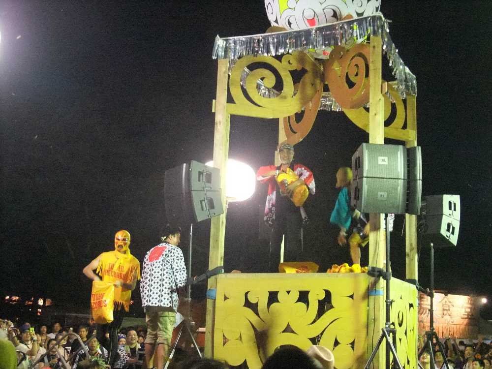 櫓からタワーレコードの景品を投げるタワーマスク。