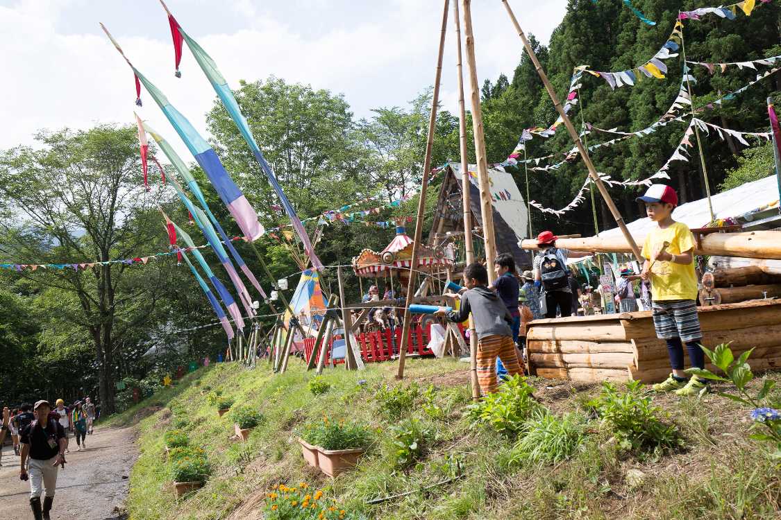 通る人に水鉄砲で水をかける子ども。