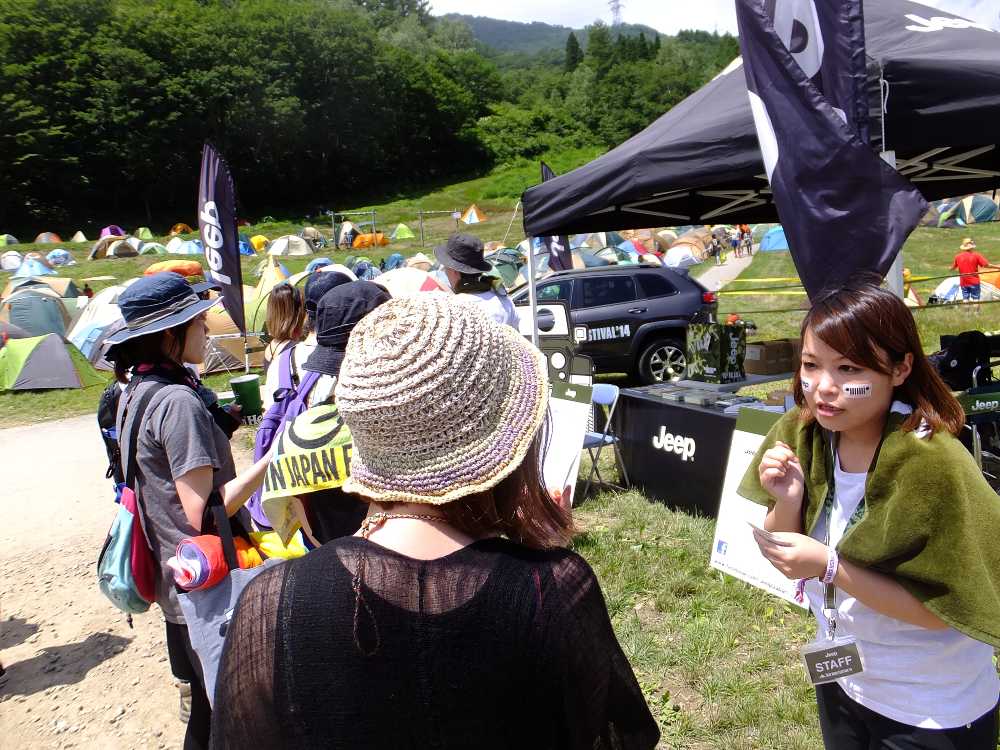 顔にジープのロゴを貼っているスタッフ。