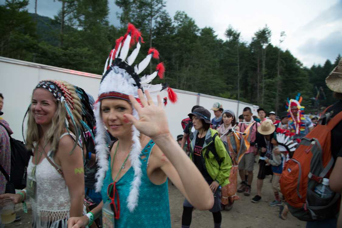 通俗化し、ファッション化した先住民の服飾で歩く外国人集団。