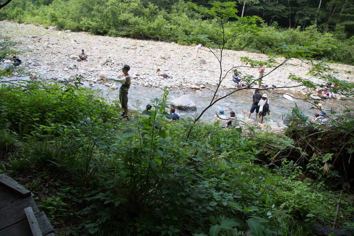 ボードウォークから降りて川に入る人。