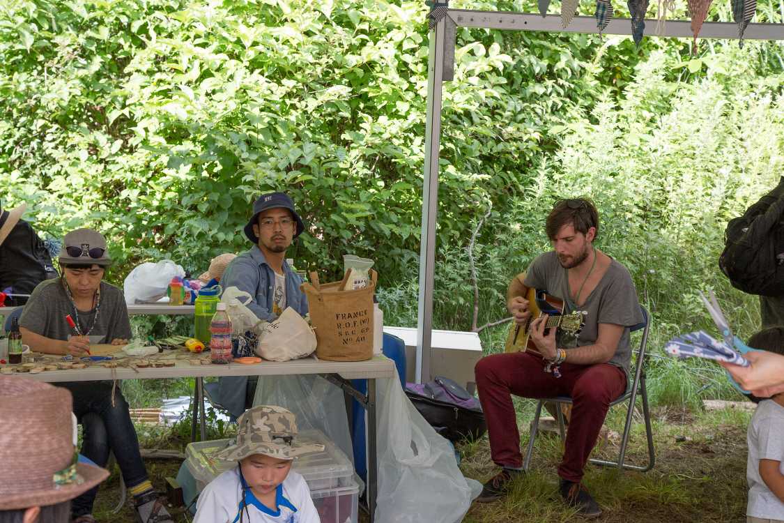 キッズテントでギターを弾く人。