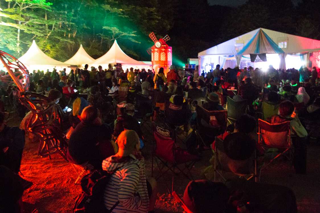 カフェ・ド・パリに入りきらない人たち。ほとんどの人はいすに座っています。