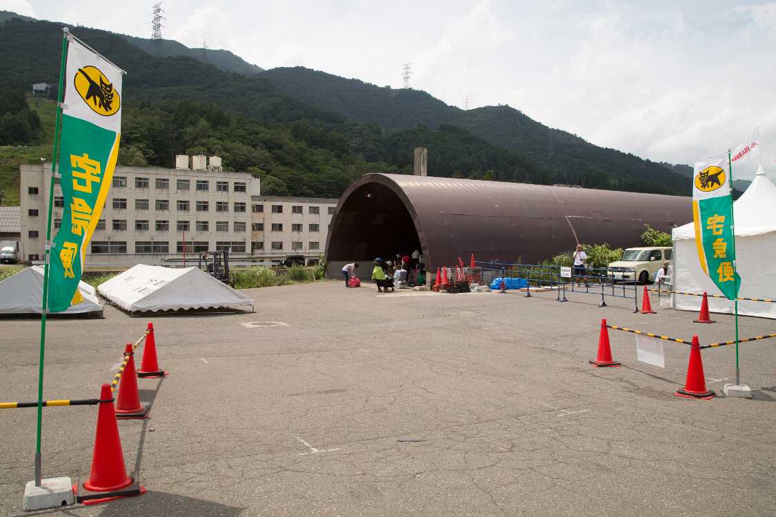 宅配便は資材庫を転用。木曜日は手前にテントを設営して受け渡しします。