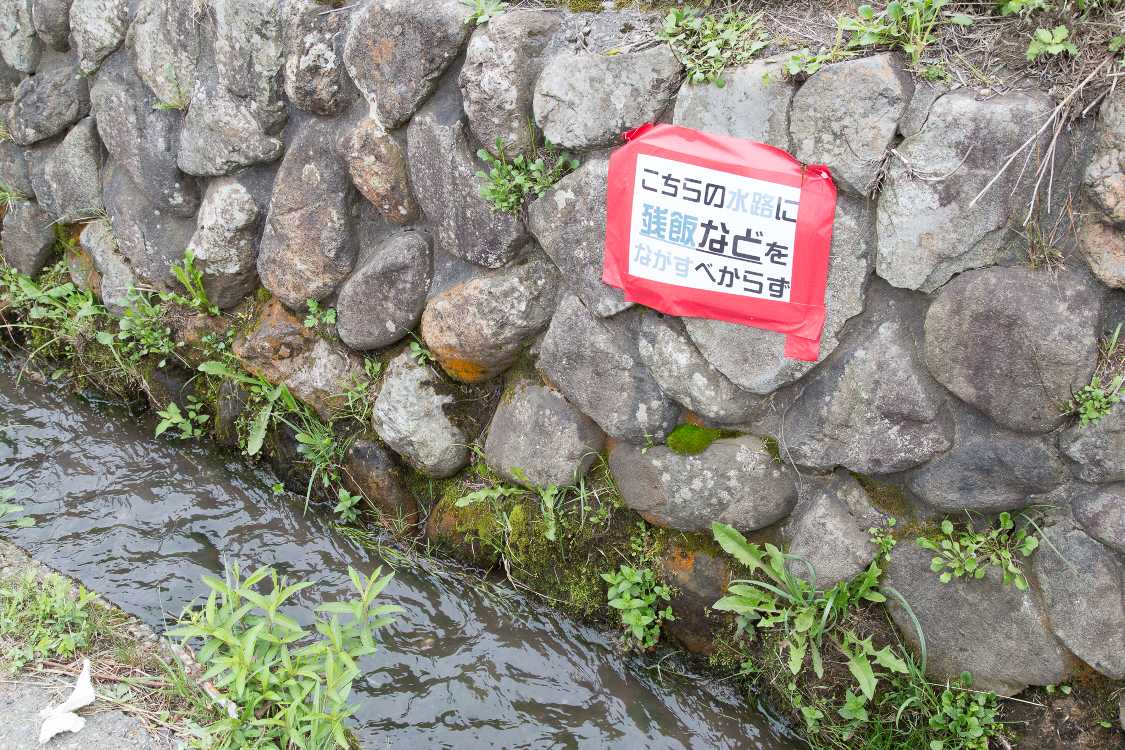 場外飲食エリアの裏。残飯捨てるなの表示。水路はそのまま浅貝川に合流します。