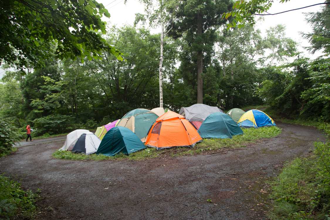 道が2つに分かれていますが、真ん中は空き地なのでテントが建っています。