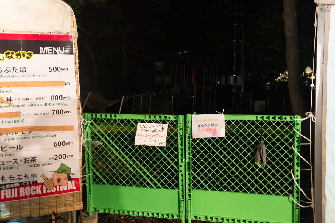 オアシスエリア出店管理テントの隣。小便するなの英語表示。