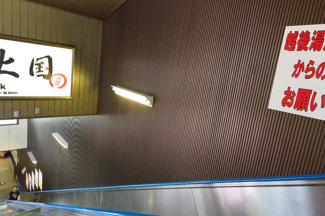 駅前のバス乗り場に降りるエスカレーター。ここも宣伝がありません。