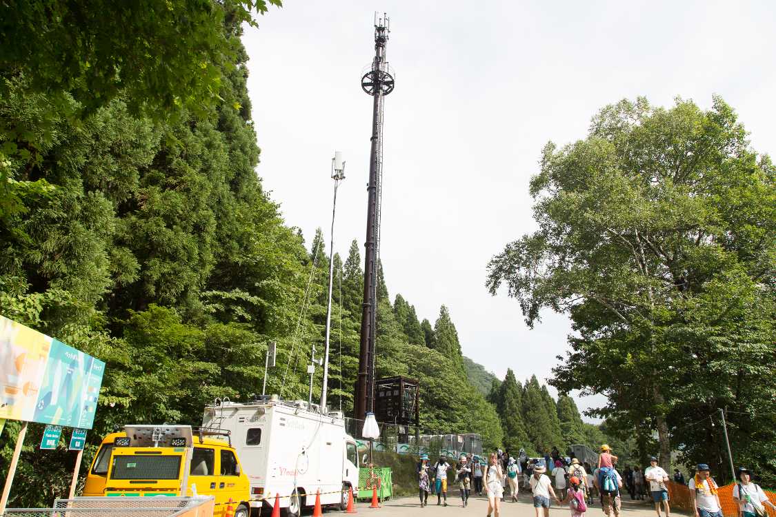 グリーンステージの奥の常設アンテナ。手前に臨時アンテナの車があります。