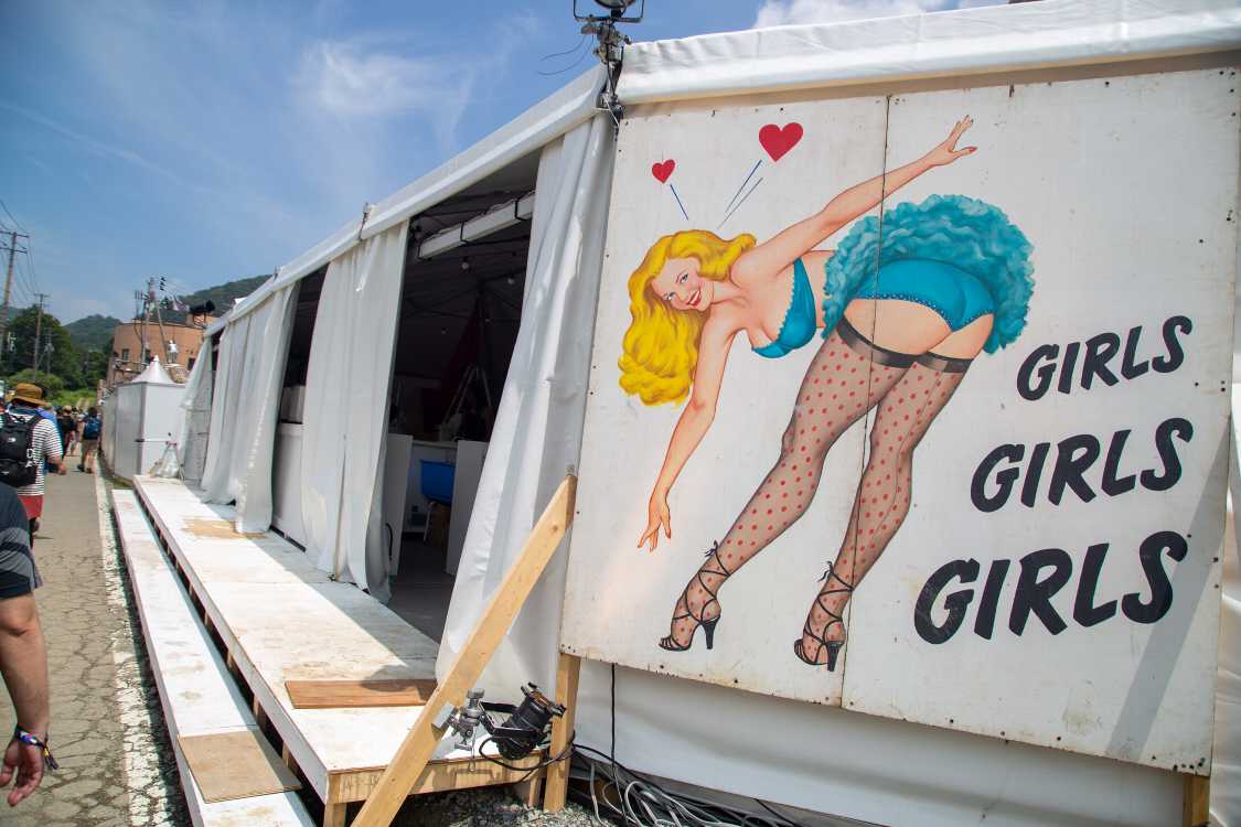 建設中のテント。「ガールズ、ガールズ、ガールズ」はエルヴィス・プレスリー主演の映画のタイトル。