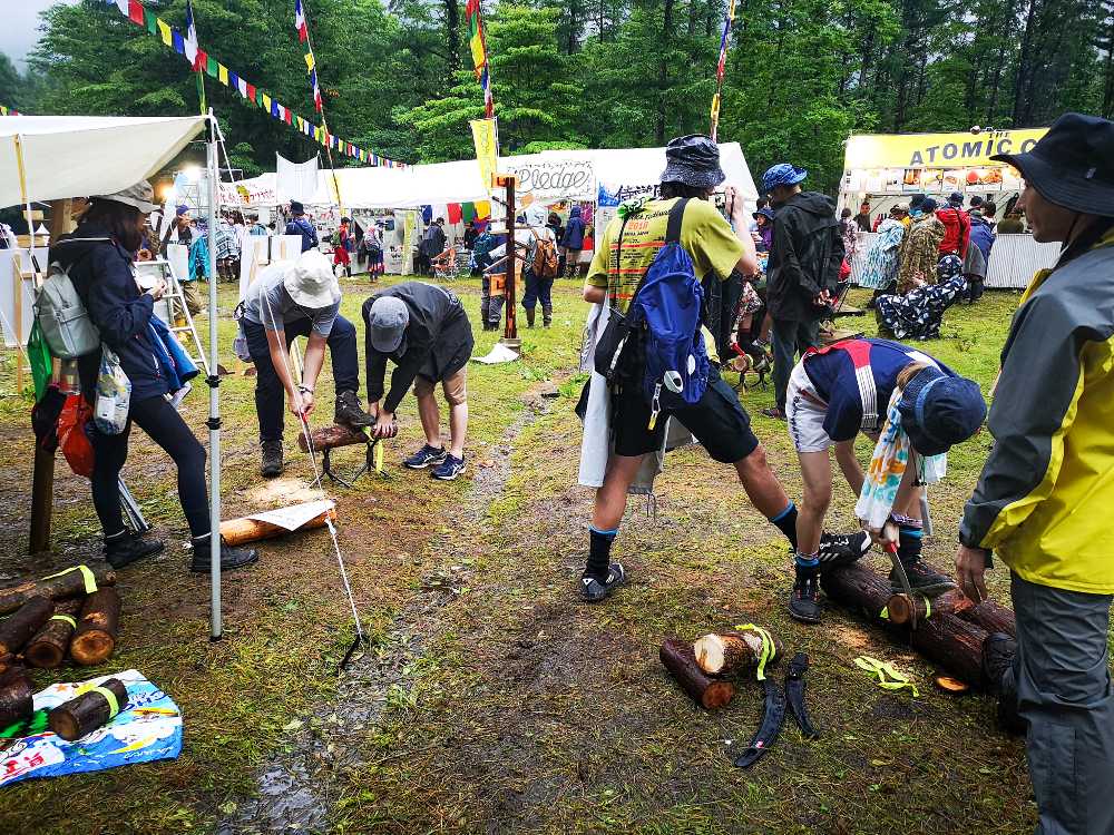 コースター用の木をのこぎりで切る人。