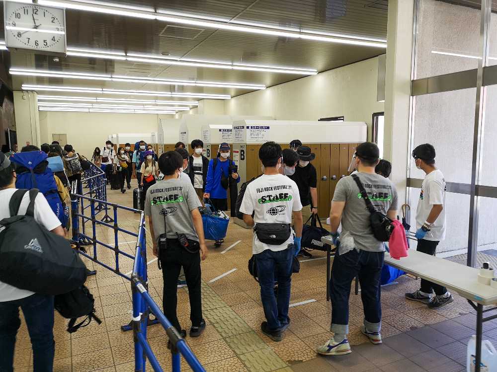 シャトルバスの客に対し体温チェック。