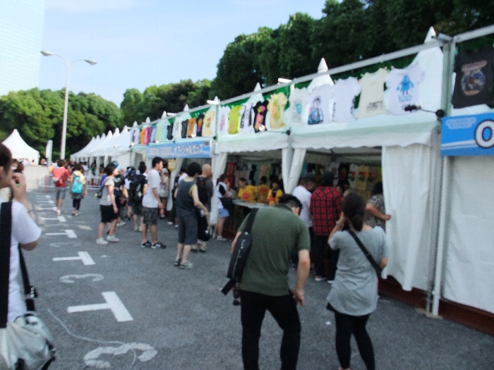 ピンぼけ。幕張メッセの3ステージに出演するアーティストのグッズ売り場。