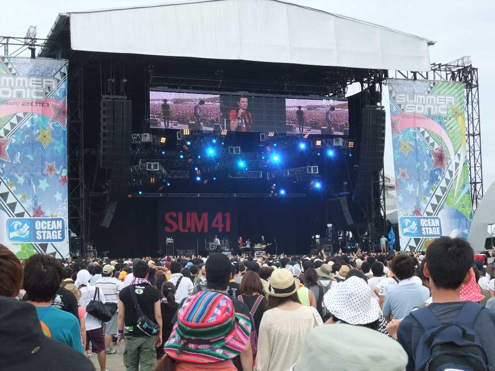 SUM41公演中。幕張会場と同じように、上部に3画面のモニター画面があります。