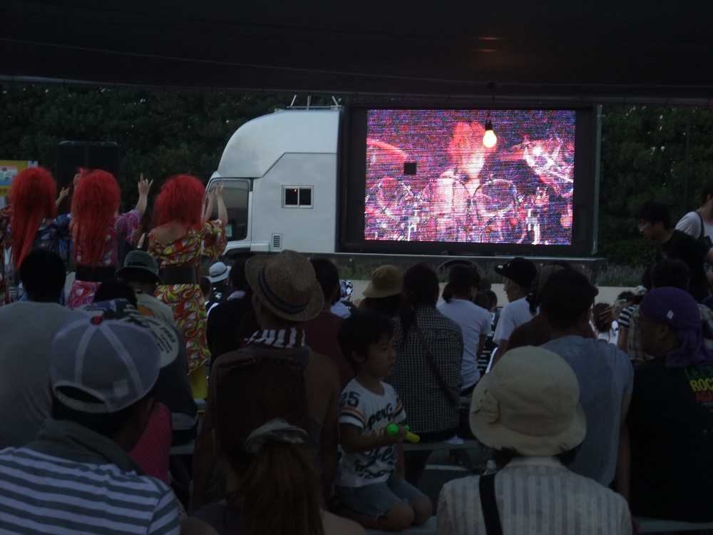 マリンステージの外でXジャパンの映像を見る人。左の人たちはファンか。