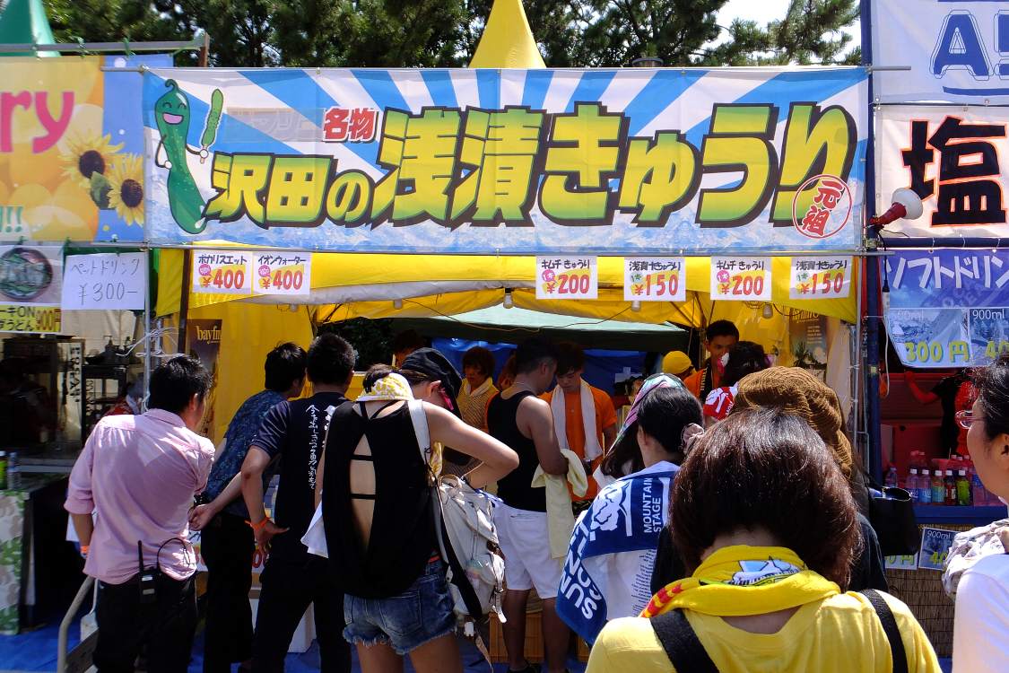 浅漬けキュウリの店。看板の「名物」の手前の「サマソニ」を隠している。外し忘れか。