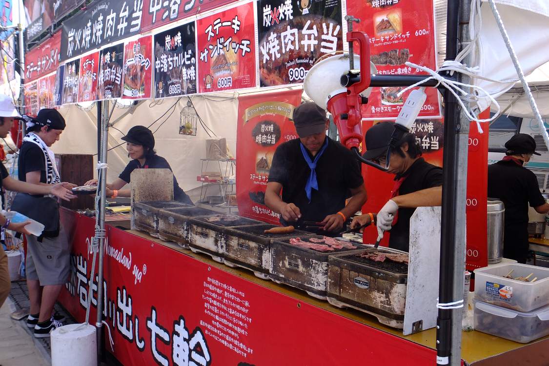 七輪風の網で肉を焼いている。