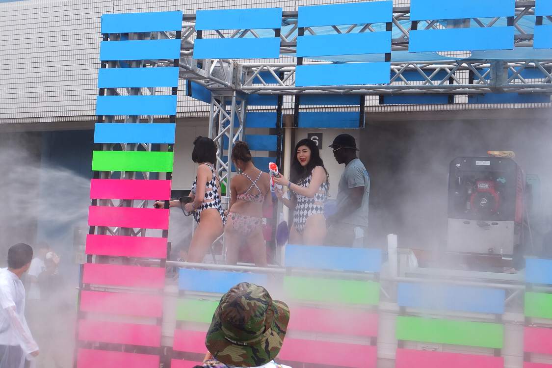 荷台で女性が水を放射。