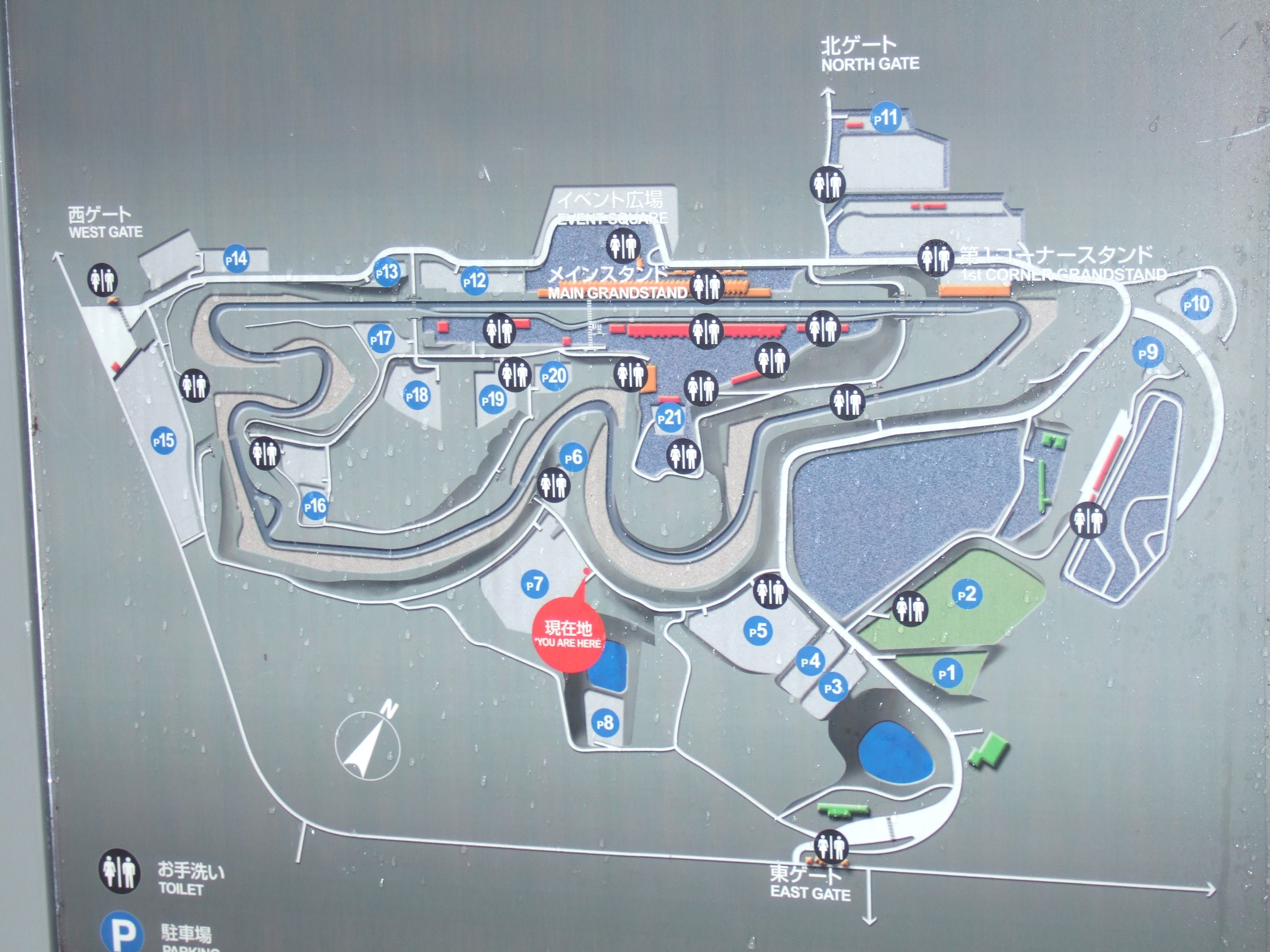 受付を過ぎてすぐにある案内板。メーン・ステージのモビリタ・ステージはメイン・スタンドにあります。当初の予定では現在地から右手の方にステージができる予定でしたが変更されました。広大な青い部分にステージができる予定だったので、右に曲がればすぐにメーン・ステージになるはずでした。